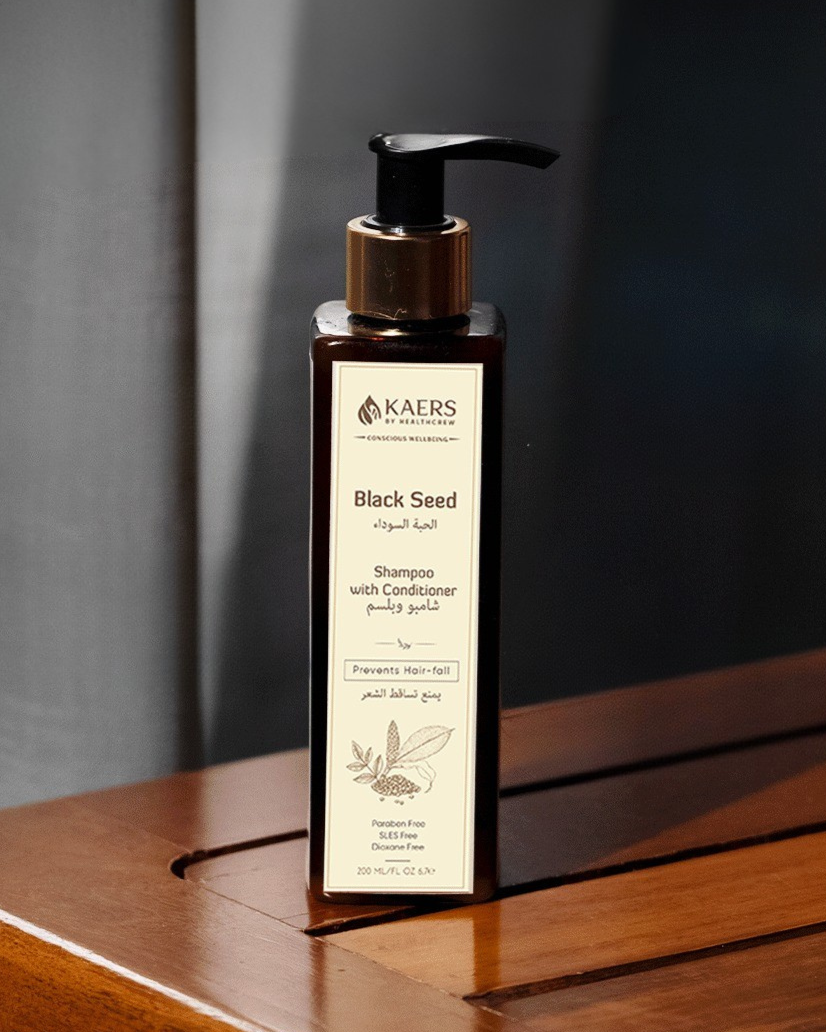 KAERS Black Seed shampoo bottle on a wooden surface with a dark background