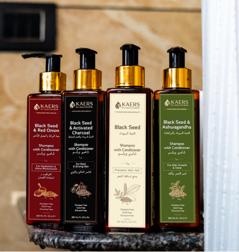 Set of KAERS haircare products on a bathroom shelf with a beige wall background.