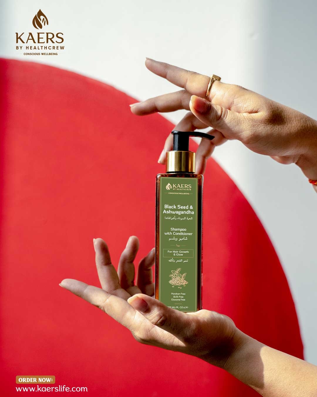 KAERS Black Seed and Ashwagandha shampoo bottle held by hands with a red and white background