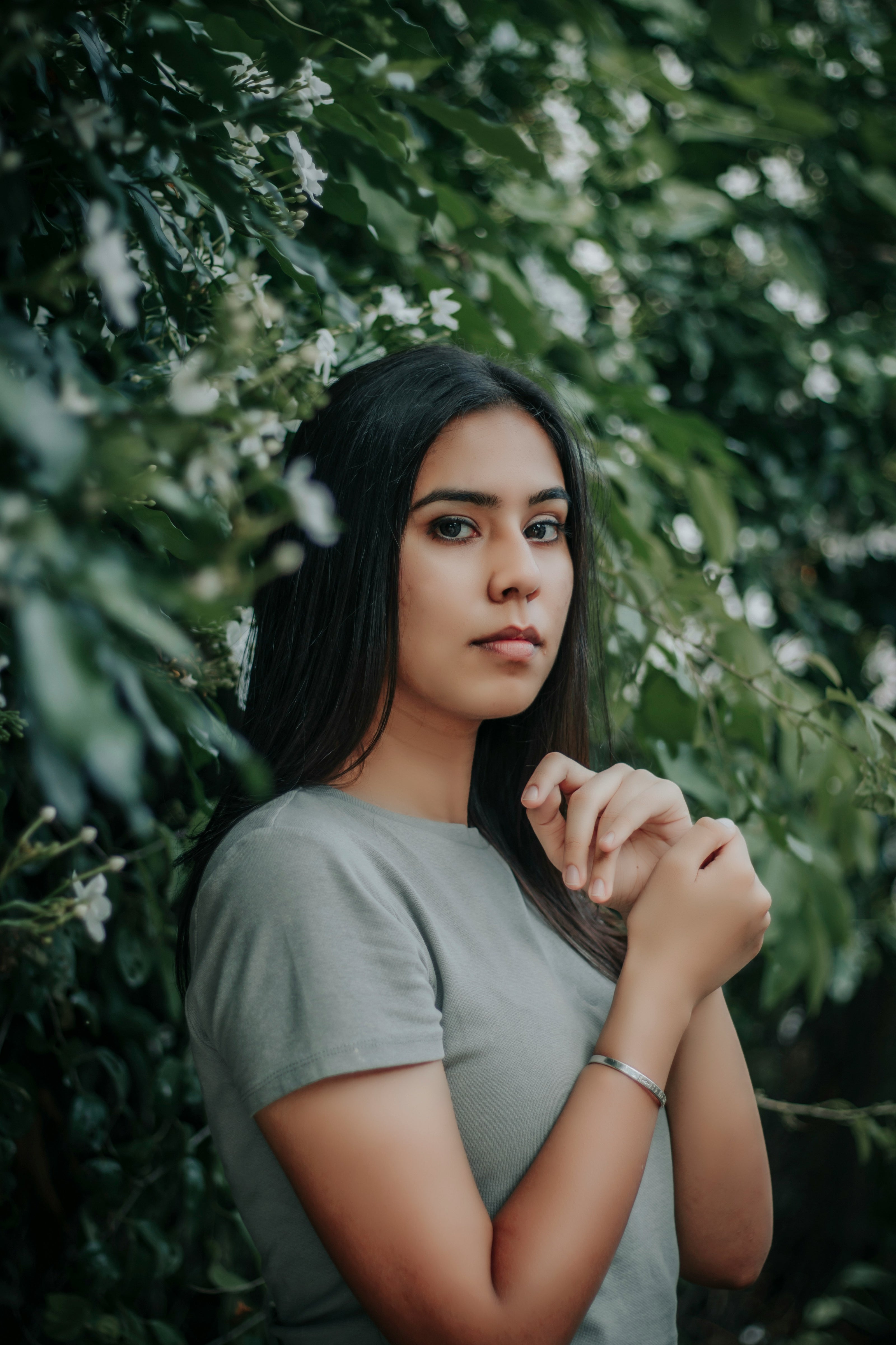 Kaers Woman with beautiful hair standing among green foliage