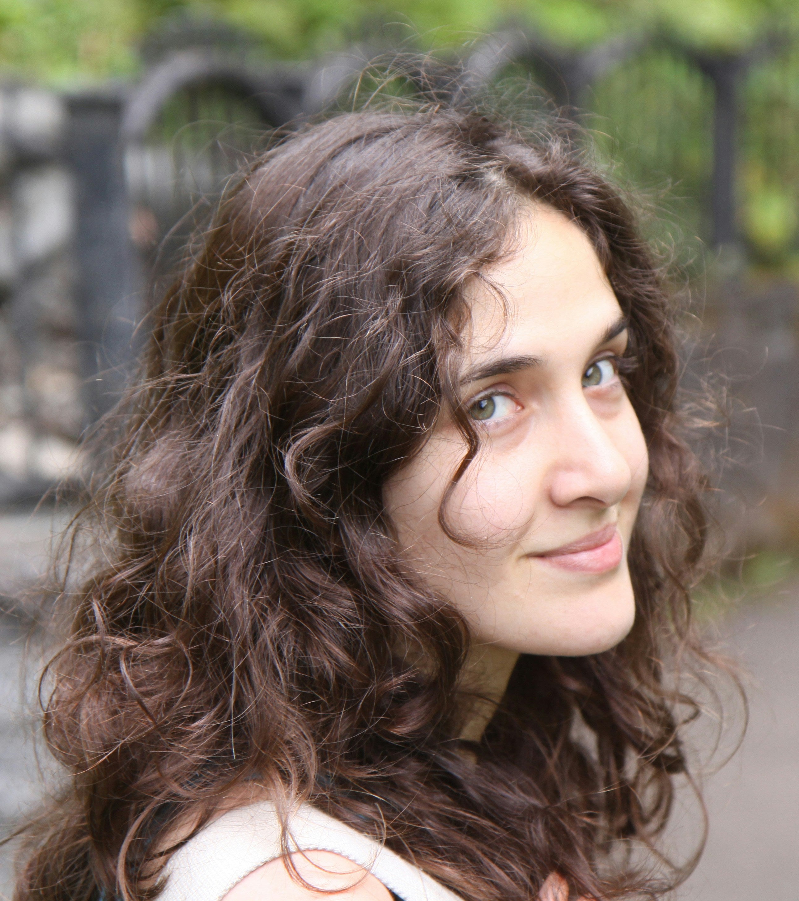 Woman with wavy brown hair outdoors
