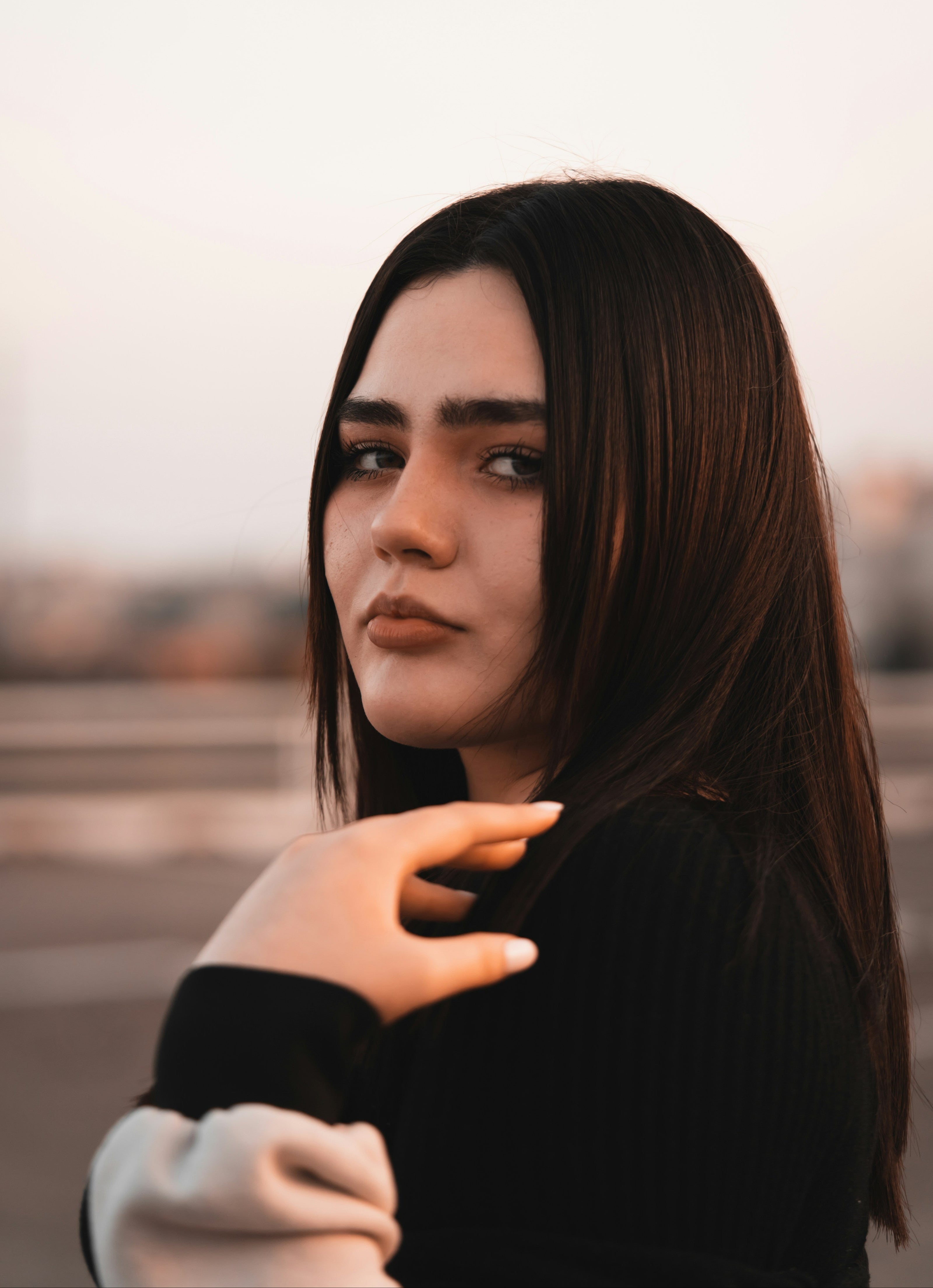 Woman with kaers long dark hair and a blurred background