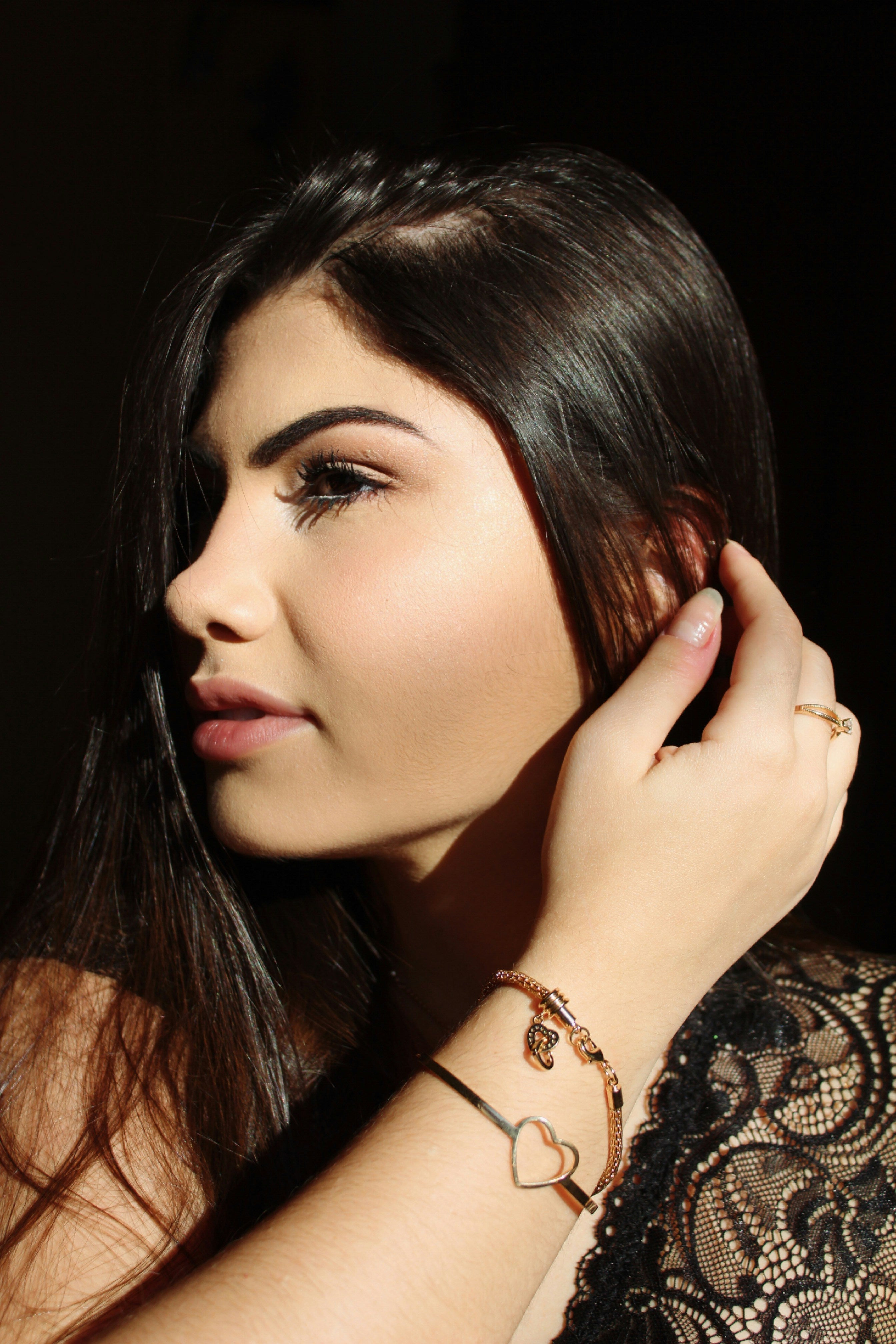 Kaers Woman adjusting her hair with a dark background